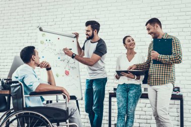 Genç işçiler Modern ofisinde konuşabilir. İş yerinde beyin fırtınası. Gülümseyen kadın. Adam tekerlekli sandalye üzerinde. Gülümseyen Yöneticisi. Office çalışmasında. Sunu planlama. Meslektaşları ile iletişim.