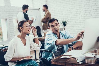 Genç işçiler Modern ofiste sohbet edelim. İş yerinde beyin fırtınası. Gülümseyen kadın. Adam tekerlekli sandalye üzerinde. Gülümseyen Yöneticisi. Office çalışmasında. Genç bir işçi. Meslektaşları ile oturan adam iletişim.