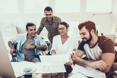 Genç işçiler Modern ofiste sohbet edelim. İş yerinde beyin fırtınası. Gülümseyen kadın. Adam tekerlekli sandalye üzerinde. Gülümseyen Yöneticisi. Office çalışmasında. Genç bir işçi. Meslektaşları ile oturan adam iletişim.