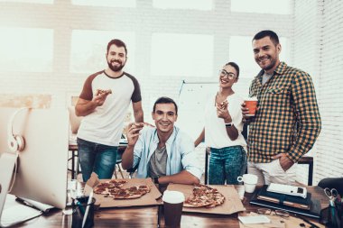 Gençler Pizza ile ofiste yemek. Office çalışmasında. Genç bir işçi. Oturan adam Pizza kutusu. Genç kız bardaklarda. Genç bir işçi. Molada Yöneticisi. Adam tekerlekli sandalye üzerinde.