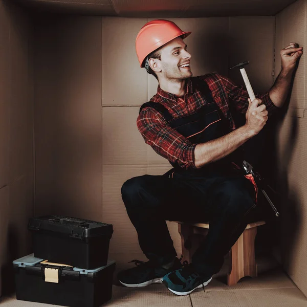 Worker Orange Helmet Sitting Cardboard Box Young Man Uniform Uncomfortable — Stock Photo, Image