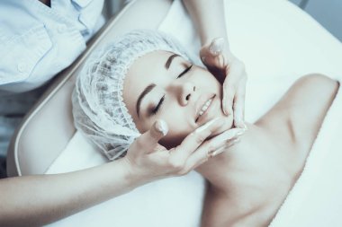 Genç kadın Masaj temizlik için Spa salonda. Kız Güzellik Salonu. Modern kozmetik. Profesyonel güzellik uzmanı. Beyaz önlük doktor. Kadın güzellik kavramı. Cilt Bakımı ve temizliği.