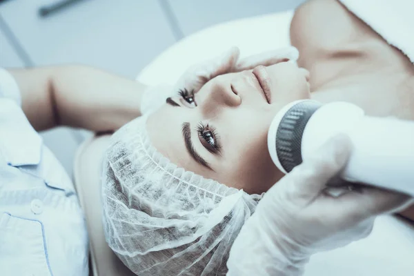 Young Woman in Spa Salon for Laser Hair Removal. Girl in Beauty Salon. Modern Cosmetology. Proffesional Cosmetologist. Doctor with Laser Epilator. Women\'s Beauty Concept. Medical Equipment.