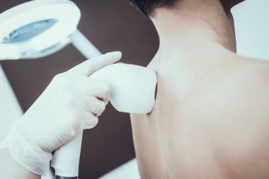 Spa Salon Lazer epilasyon için genç adam. Güzellik Salonu adam. Modern kozmetik. Profesyonel güzellik uzmanı. Doktor lazer epilatör ile. Erkek güzellik kavramı. Gözlüklü adam.
