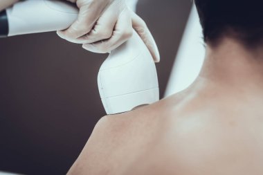 Spa Salon Lazer epilasyon için genç adam. Güzellik Salonu adam. Modern kozmetik. Profesyonel güzellik uzmanı. Doktor lazer epilatör ile. Erkek güzellik kavramı. Gözlüklü adam.