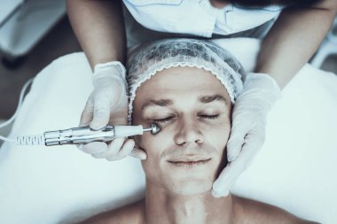 Spa Salon Lazer epilasyon için genç adam. Güzellik Salonu adam. Modern kozmetik. Profesyonel güzellik uzmanı. Doktor lazer epilatör ile. Erkek güzellik kavramı. Tıbbi donatımı.