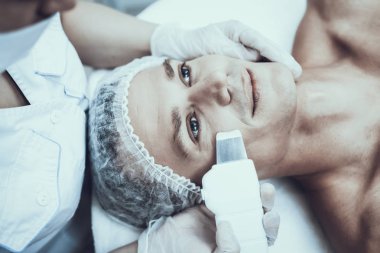 Spa Salon Lazer epilasyon için genç adam. Güzellik Salonu adam. Modern kozmetik. Profesyonel güzellik uzmanı. Doktor lazer epilatör ile. Erkek güzellik kavramı. Tıbbi donatımı.