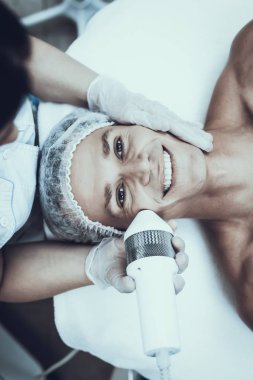 Spa Salon Lazer epilasyon için genç adam. Güzellik Salonu adam. Modern kozmetik. Profesyonel güzellik uzmanı. Doktor lazer epilatör ile. Erkek güzellik kavramı. Tıbbi donatımı.