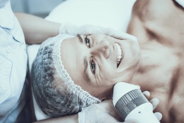 Spa Salon Lazer epilasyon için genç adam. Güzellik Salonu adam. Modern kozmetik. Profesyonel güzellik uzmanı. Doktor lazer epilatör ile. Erkek güzellik kavramı. Tıbbi donatımı.