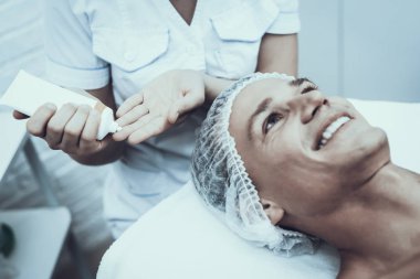 Spa salonda masaj temizlik için genç adam. Güzellik Salonu adam. Modern kozmetik. Profesyonel güzellik uzmanı. Beyaz önlük doktor. Erkek güzellik kavramı. Cilt Bakımı ve temizliği.