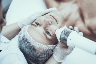 Spa Salon Lazer epilasyon için genç adam. Güzellik Salonu adam. Modern kozmetik. Profesyonel güzellik uzmanı. Doktor lazer epilatör ile. Erkek güzellik kavramı. Tıbbi donatımı.