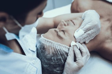 Spa salonda masaj temizlik için genç adam. Güzellik Salonu adam. Modern kozmetik. Profesyonel güzellik uzmanı. Beyaz önlük doktor. Erkek güzellik kavramı. Cilt Bakımı ve temizliği.