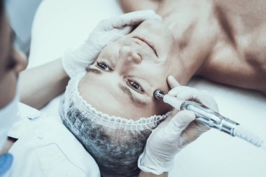 Spa Salon Lazer epilasyon için genç adam. Güzellik Salonu adam. Modern kozmetik. Profesyonel güzellik uzmanı. Doktor lazer epilatör ile. Erkek güzellik kavramı. Tıbbi donatımı.