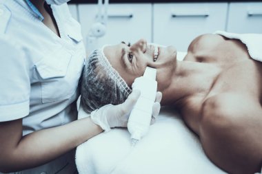 Spa Salon Lazer epilasyon için genç adam. Güzellik Salonu adam. Modern kozmetik. Profesyonel güzellik uzmanı. Doktor lazer epilatör ile. Erkek güzellik kavramı. Tıbbi donatımı.