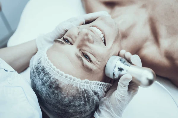 Spa Salon Lazer epilasyon için genç adam. Güzellik Salonu adam. Modern kozmetik. Profesyonel güzellik uzmanı. Doktor lazer epilatör ile. Erkek güzellik kavramı. Tıbbi donatımı.