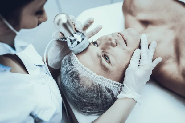 Spa Salon Lazer epilasyon için genç adam. Güzellik Salonu adam. Modern kozmetik. Profesyonel güzellik uzmanı. Doktor lazer epilatör ile. Erkek güzellik kavramı. Tıbbi donatımı.