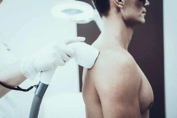 Depilación láser del pecho de un hombre cuidado del cuerpo masculino un  hombre con gafas protectoras y el pecho desnudo se somete a un  procedimiento de depilación láser en una clínica