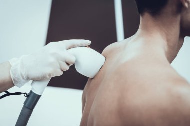 Spa Salon Lazer epilasyon için genç adam. Güzellik Salonu adam. Modern kozmetik. Profesyonel güzellik uzmanı. Doktor lazer epilatör ile. Erkek güzellik kavramı. Gözlüklü adam.