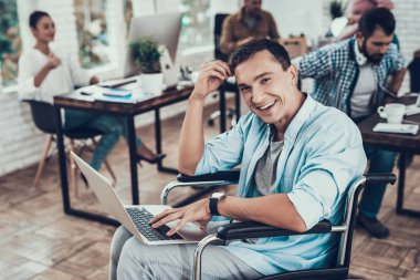 Ofiste Laptop ile Tekerlekli Sandalyede Engelli Adam. Engelli Genç Adam. Tekerlekli Sandalyedeki Adam. Kurtarma ve Sağlık Kavramları. Ofiste takım çalışması. Genç İşçi. Oturan Adam. Laptop ile İşçi.