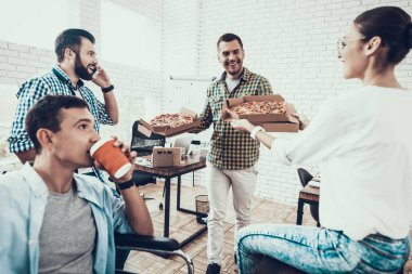 Gençler Pizza ile ofiste yemek. Office çalışmasında. Genç bir işçi. Oturan adam Pizza kutusu. Genç kız bardaklarda. Genç bir işçi. Molada Yöneticisi. Adam tekerlekli sandalye üzerinde.