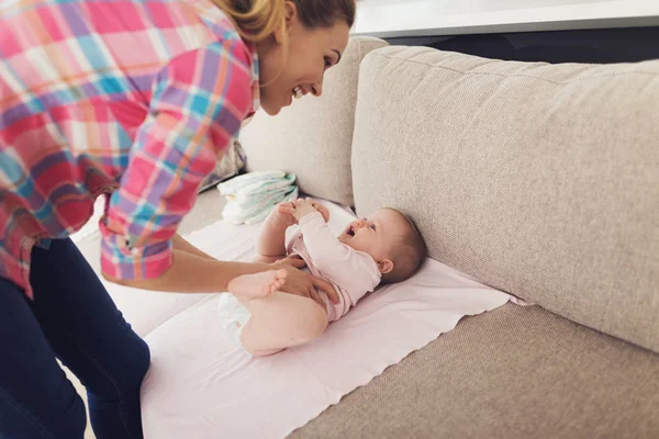 Careful Mother Swaddles Smiling Baby Couch Happy Mom Wears Casual — Stock Photo, Image