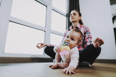 Şirin bebek oynarken annesi Meditates katta. Portre tatlı sevimli güzel beyaz çocuk oyuncak elinde tutan ve ağız oturma odasında. Annelik ve çocukluk kavramı