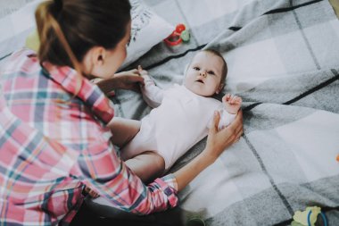 Mutlu halı üzerinde yalan ile şirin bebek anne çalış. Gülümseyen anne ile tatlı güzel Beyaz Toddler oturma odasında istirahat rahat kıyafetler giyer. Çocukluk ve annelik kavramı