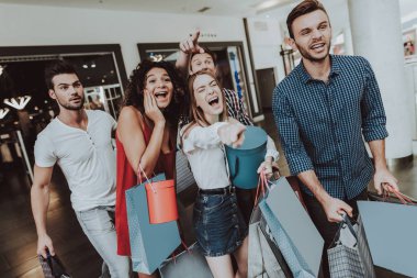 Paketleri ile alışveriş merkezinde alışveriş arkadaş şirket. Alışveriş kavramı. Kırmızı elbiseli kız. Kadın beyaz gömlekli. Siyah Cuma kavramı. Çıktıktan gençler. Modern pazar. Elinde paketleri.