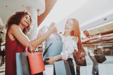 Modern alışveriş merkezinde alışveriş paketleri olan genç kadın. Alışveriş kavramı. Kırmızı elbiseli kız. Kadın beyaz gömlekli. Siyah Cuma kavramı. Mutlu kadın. Paketleri tutarak. Paketi elinde alışveriş merkezi.