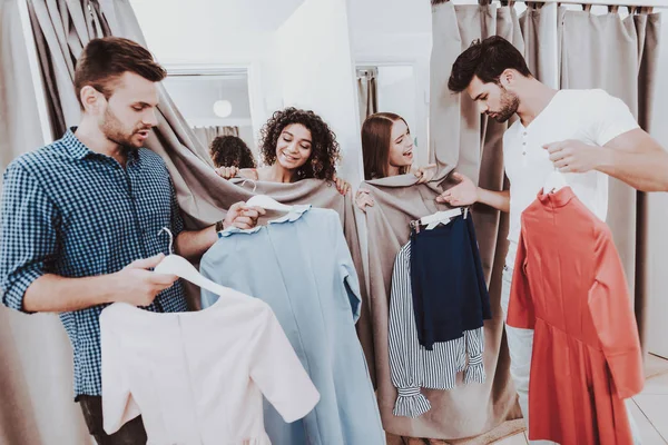 Young Couples in Dressing Room in Modern Boutique. Boyfriend with Girlfriend. Bearded Man. Woman on Shopping. Shopping in Modern Mall. Red Dress. Dressing Room in Boutique. Standing People.