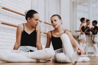 Kızlar bale eğitimi sonra yerde dinleniyor. Klasik bale. Kız balerin Tutu. Kapalı eğitim. Şirin dansçılar. Ahşap yerde yatıyor. Pratik dans. Kızlar beyaz elbiseler.