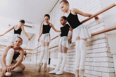 Genç kızların kapalı grubunun bale eğitimi. Klasik bale. Kız balerin Tutu. Kapalı eğitim. Şirin dansçılar. Performans salonunda. Pratik dans. Kızlar beyaz elbiseler.