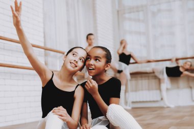 Kızlar bale eğitimi sonra yerde dinleniyor. Klasik bale. Kız balerin Tutu. Kapalı eğitim. Şirin dansçılar. Ahşap yerde yatıyor. Pratik dans. Kızlar beyaz elbiseler.