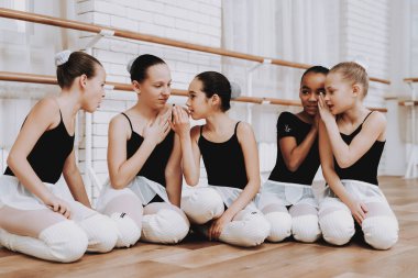 Kızlar bale eğitimi sonra yerde dinleniyor. Klasik bale. Kız balerin Tutu. Kapalı eğitim. Şirin dansçılar. Ahşap yerde yatıyor. Pratik dans. Kızlar beyaz elbiseler.