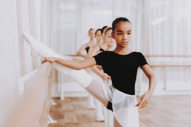 Genç kızların kapalı grubunun bale eğitimi. Klasik bale. Kız balerin Tutu. Kapalı eğitim. Şirin dansçılar. Performans salonunda. Pratik dans. Kızlar beyaz elbiseler.