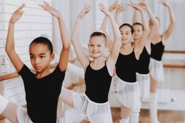 Genç kızların kapalı grubunun bale eğitimi. Klasik bale. Kız balerin Tutu. Kapalı eğitim. Şirin dansçılar. Performans salonunda. Pratik dans. Kızlar beyaz elbiseler.