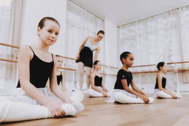 Bale eğitimi öğretmen ile kattaki kızlardan. Klasik bale. Kız balerin Tutu. Kapalı eğitim. Şirin dansçılar. Ahşap zemin üzerinde performans. Pratik dans. Kızlar beyaz elbiseler.