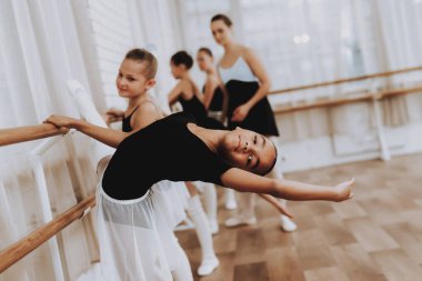 Bale eğitimi Öğretmen kızlarla grup. Klasik bale. Kız balerin Tutu. Kapalı eğitim. Şirin dansçılar. Performans salonunda. Pratik dans. Kızlar beyaz elbiseler.