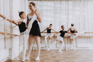 Bale eğitimi Öğretmen kızlarla grup. Klasik bale. Kız balerin Tutu. Kapalı eğitim. Şirin dansçılar. Performans salonunda. Pratik dans. Kızlar beyaz elbiseler.