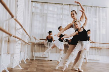 Bale eğitimi Öğretmen kızlarla grup. Klasik bale. Kız balerin Tutu. Kapalı eğitim. Şirin dansçılar. Performans salonunda. Pratik dans. Kızlar beyaz elbiseler.