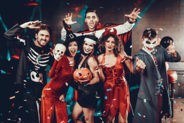 Genç gülümseyen insanlar korkunç kostümleri portresi. Grup Genç mutlu arkadaşlar giyen Halloween eğlenceli yiyorsunuz ve gece kulübünde grup fotoğrafı için poz kostümleri. Cadılar Bayramı kutlama