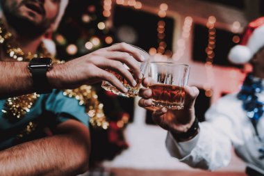 İki gülümseyen doktor ofisinde yılbaşı kutlamak. Santa Claus şapkalı adam. Ofiste Noel ağacı. Bilgisayar masasında. Beyaz ceketli adam. İçki içerken. Yeni yıl partisi. Meslektaşım ile kutlama.