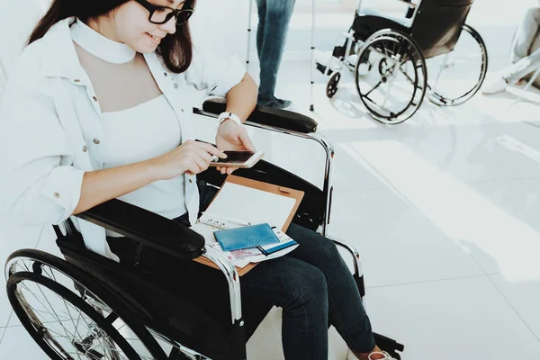 轮椅上的人在大厅里残疾 轮椅上的女人拐杖上的人 客房享有全景 灰色沙发 白色内饰 禁用的写入消息 有限的机会 残疾妇女 — 图库照片