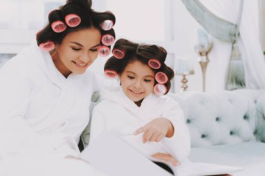 Curlers ile küçük hanım. Anne ve kızı Spa. Consept güzellik salonu. Güzel küçük hanım. Güzel yüzüm. Kadın ve mutlu bir çocuk. Curlers kadınla. Gülümseyen kişi. Spa salonda mavi kanepe