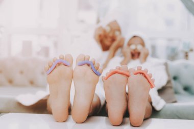 Spa Güzellik Salonu günde. Kafa havluya. Pedikür olun. Anne ve kızı Spa. Consept güzellik salonu. Güzel yüzüm. Kadın ve mutlu bir çocuk. Curlers kadınla. Selfie yapıyor. Spa salonda mavi kanepe