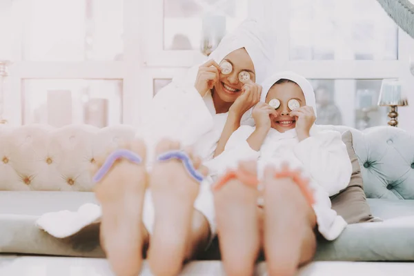 Spa Day in Beauty Salon. Towel on Head. Face Beauty Mask. Mother and Daughter in Spa. Consept Beauty Salon. Beautiful Face. Woman and Happy Child. Woman with Curlers. Doing Selfie. Blue Sofa in Salon