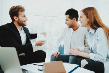 Genç bir çift. Rieltor kavramı ile Toplantı. Parlak Office. Bir sözleşme yaparak. Bir emlak alımı. Panoramik pencerelere. İş görüşmesi. Müşteri ve alıcı. Tartışma sunuyoruz. Profesyonel sözleşme.