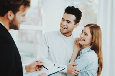 Genç bir çift. Rieltor kavramı ile Toplantı. Parlak Office. Bir sözleşme yaparak. Bir emlak alımı. Panoramik pencerelere. İş görüşmesi. Müşteri ve alıcı. Tartışma sunuyoruz. Profesyonel sözleşme.