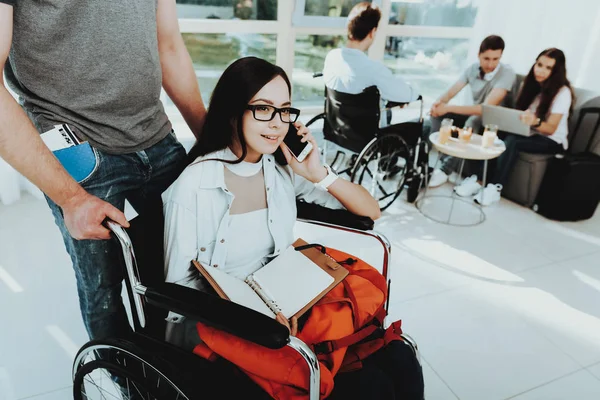 People in Wheelchair. Disabled in Hall. Woman in Wheelchair. Room with Panoramic View. Gray Sofa. Disabled in White Interior. Meeting Friends Disabled. Young Woman Disabled. Limited Opportunities.