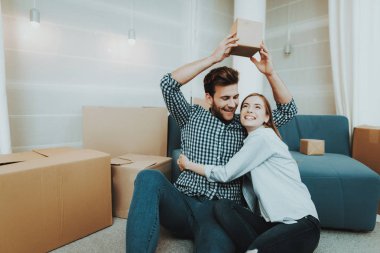 Yeni bir daire için bir hareket sırasında genç bir çift. Yeni bir konut yeni evliler. Aile içi yaşam. Yeni bir hayat. Kişisel düz. Mutlu bir aile. Neşeli şekerler. Dolu çanta. Tehcir kavramı.